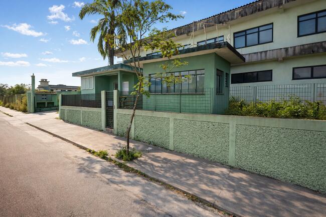 Galpão industrial de padrão médio com fachada em alvenaria rebocada, portão em ferro e esquadrias em alumínio — pronto para operação imediata com pequenas adequações.